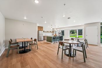 A dining room with a table surrounded by chairs.